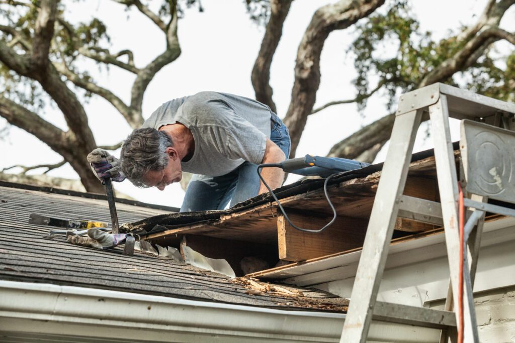 Roofer fixing a hole in the roof replacement in monument